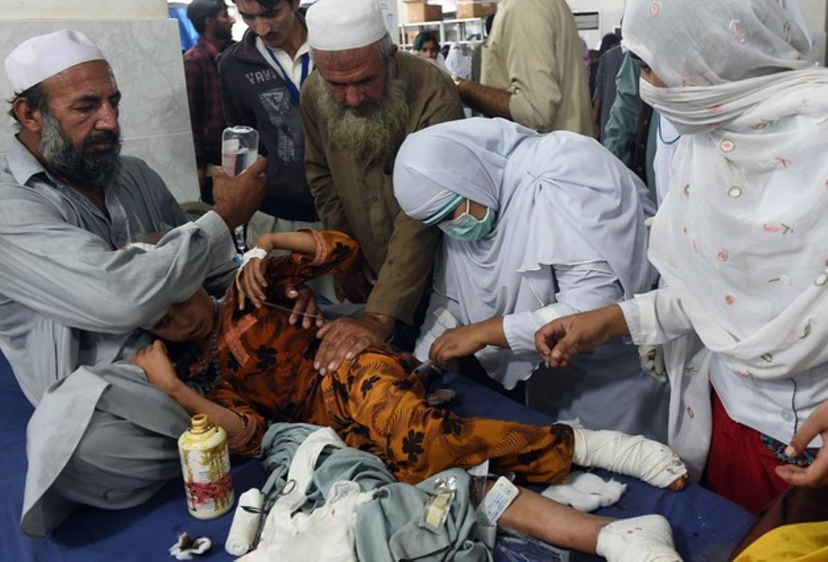 Personal sanitario atiende en la localidad paquistaní de Peshawar a una herida en el terremoto.