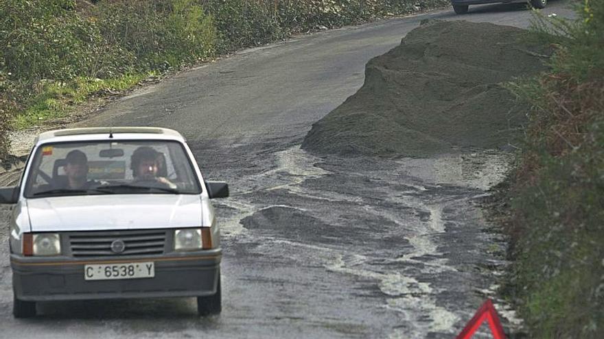 Un coche pasa junto a un triángulo rojo de emergencia. |   // L.O.