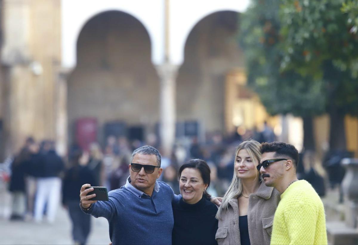 Una familia se toma una foto en el Patio de los Naranjos.