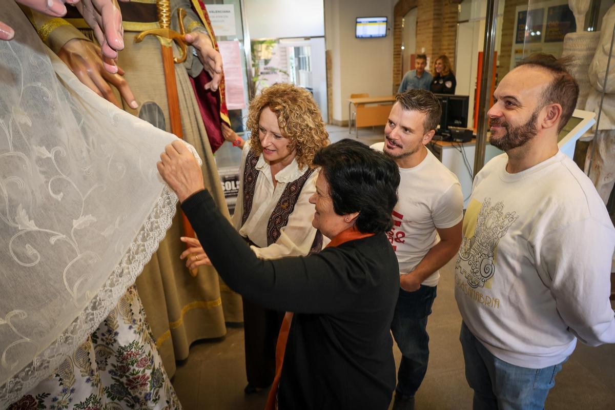 Los autores y la alcaldesa miran la indumentaria de la geganta