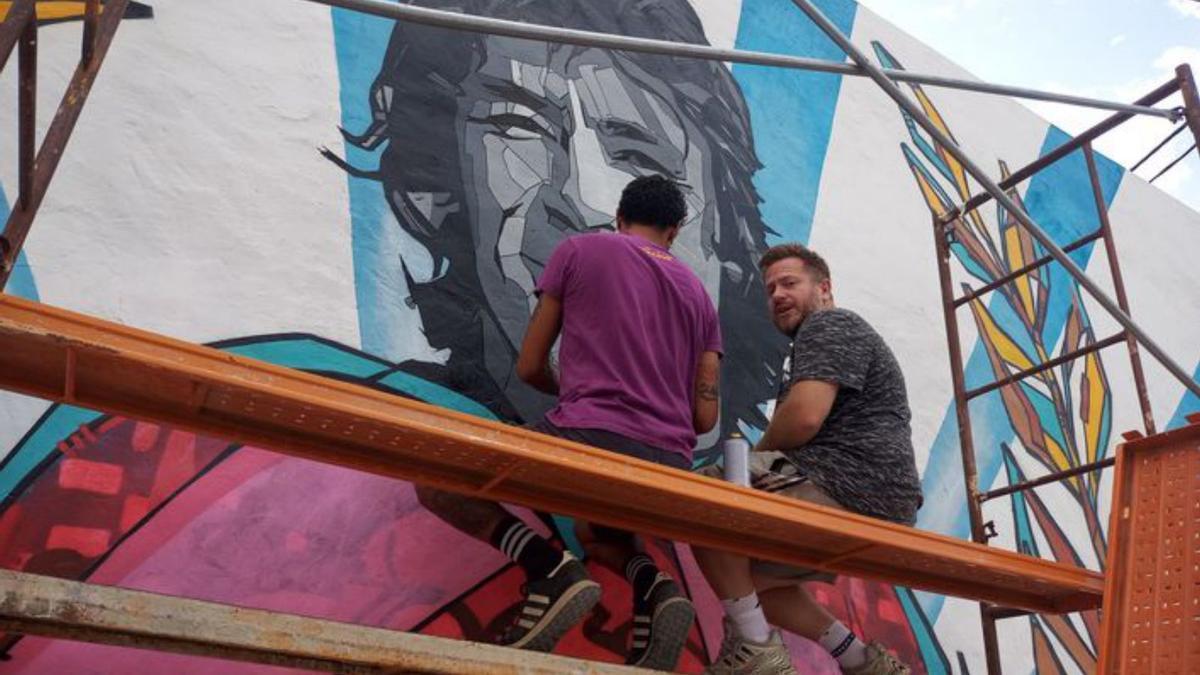 El mural y los artistas durante el proceso de creación del nuevo diseño. 