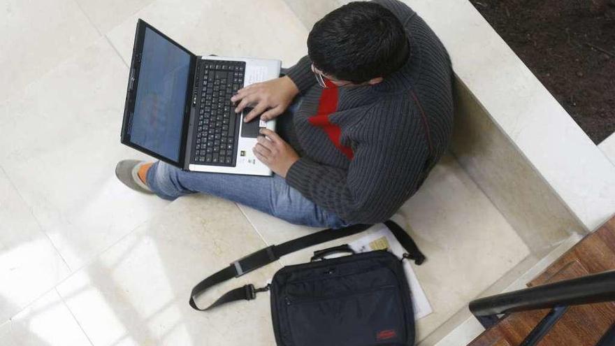 Un universitario utiliza su portátil en una facultad gallega.