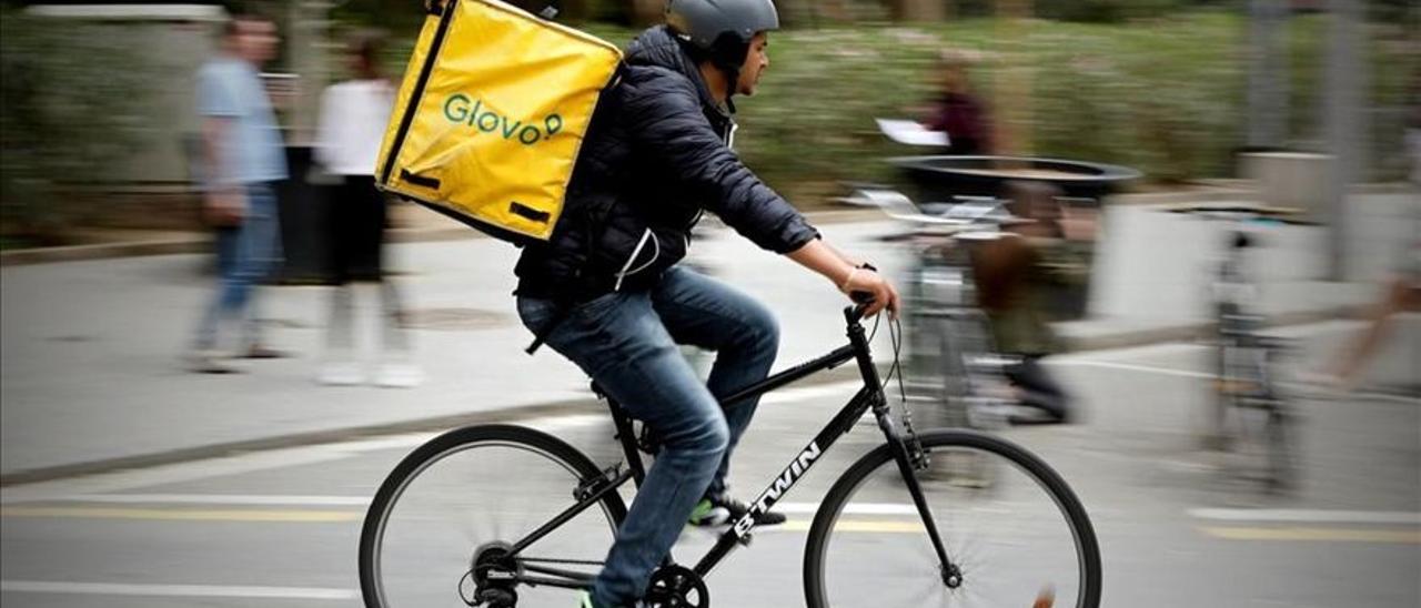 Un repartidor de Glovo pedaleando en Barcelona.