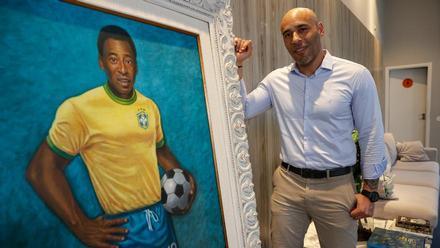 Edinho, hijo de O Rei Pelé, junto a un retrato de su padre