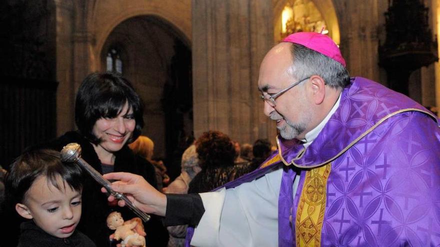 El Arzobispo bendice uno de los Niños Jesús que llevaron los pequeños ayer a la Catedral.