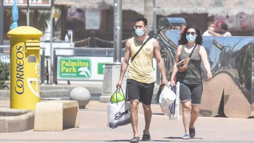 Turistas con mascarillas en la playa de Maspalomas.