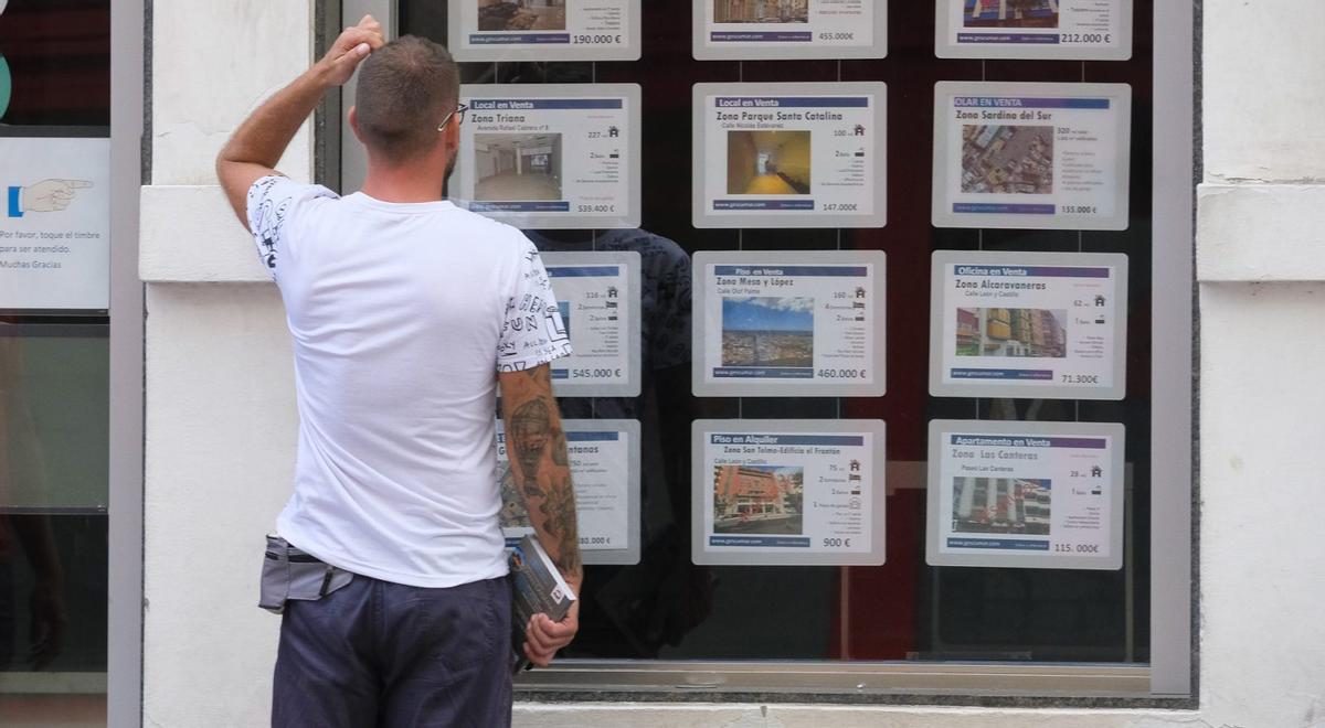 Un hombre mira el escaparate de una agencia inmobiliaria en Canarias.