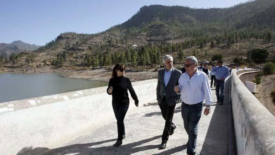 El consejero de Obras Públicas del Cabildo, Carlos Sánchez (centro), y el gerente del Consejo Insular de Aguas, José Luis Guerra, en la presa de Chira.  i ACFI