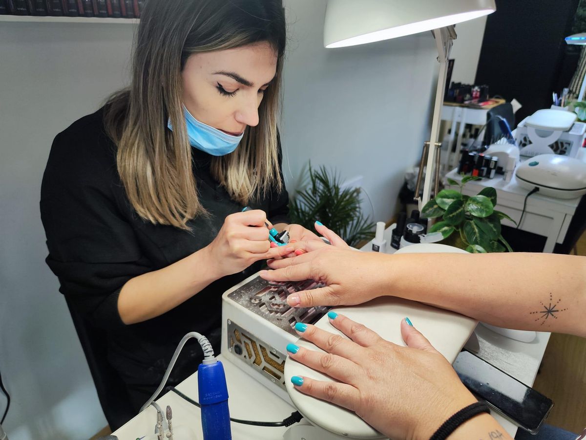 Raquel García, con una clienta, ayer, en su local de la Pola.