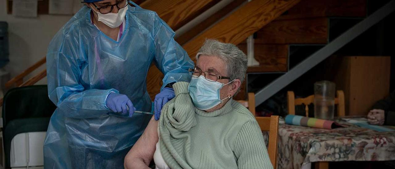 Un sanitario dispensa la vacuna contra el COVID a un anciano en Allariz.