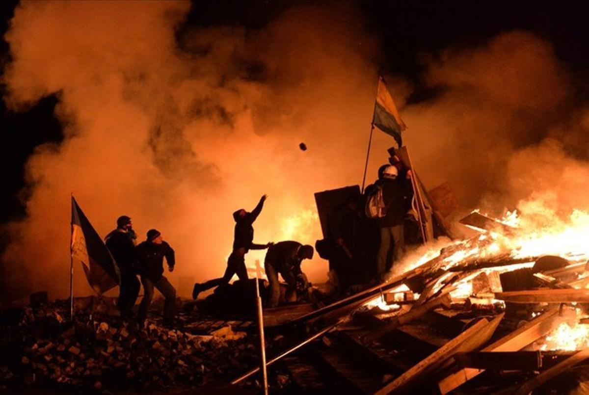 Los manifestantes antigubernamentales lanzan adoquines contra la policía en la Plaza de la Independencia en Kiev.