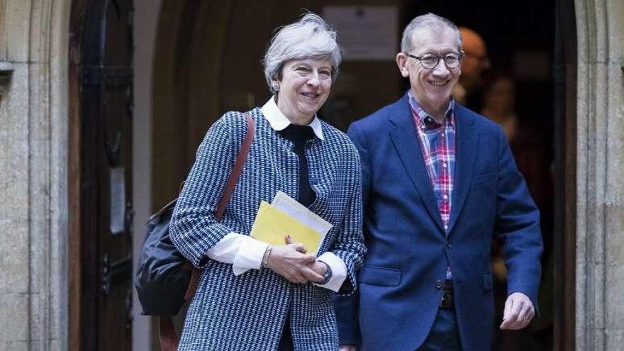 Theresa May, ayer a su salida del oficio dominical junto a su marido.