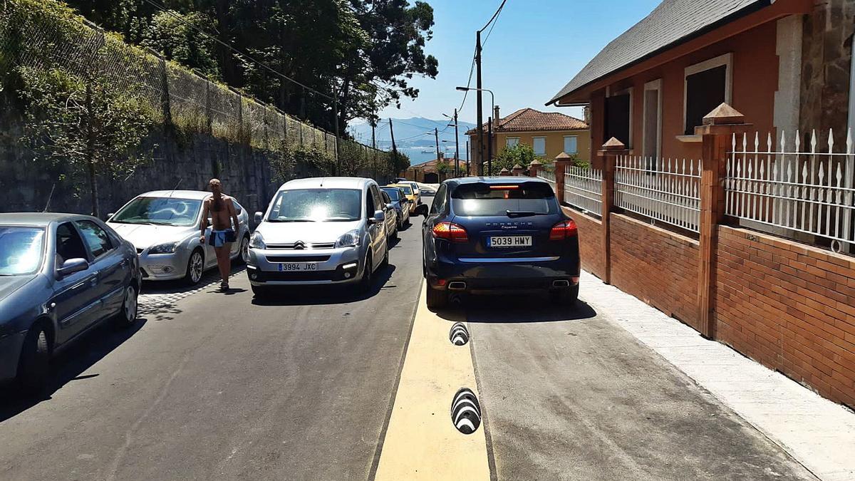 La rúa Garita, que discurre pegada al colegio Casa de la Virgen,  hacia la punta de la playa de Rodeira., llena de coches.   | // G.N.