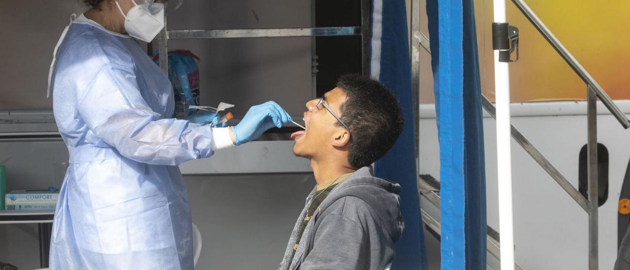 Un joven, haciéndose una prueba de saliva para saber si tiene COVID. |   // MIKI LÓPEZ