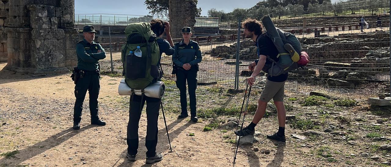 Agentes de la Guardia Civil junto a peregrinos a su paso por el yacimiento cacereño de Cáparra.