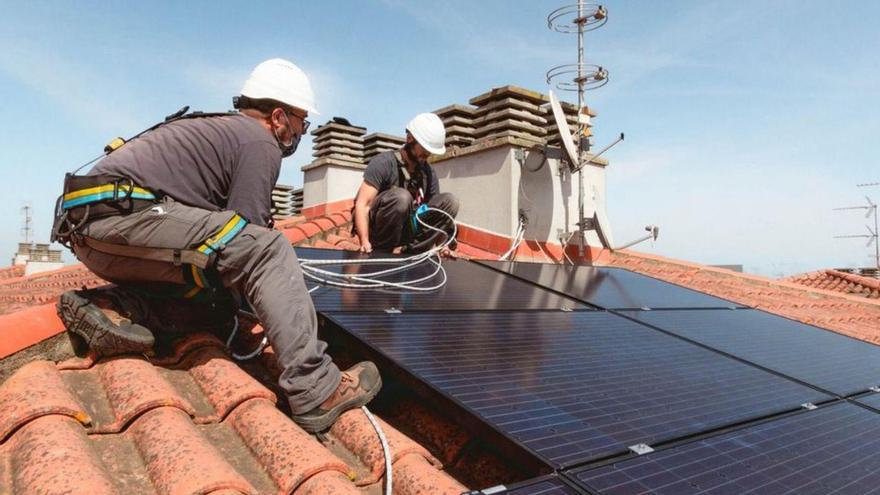 Dos trabajadores de SolarProfit instalan placas fotovoltacias.