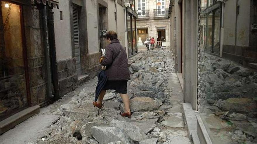 Una mujer sortea los escombros para atravesar la Calle General Mola. / fran martínez