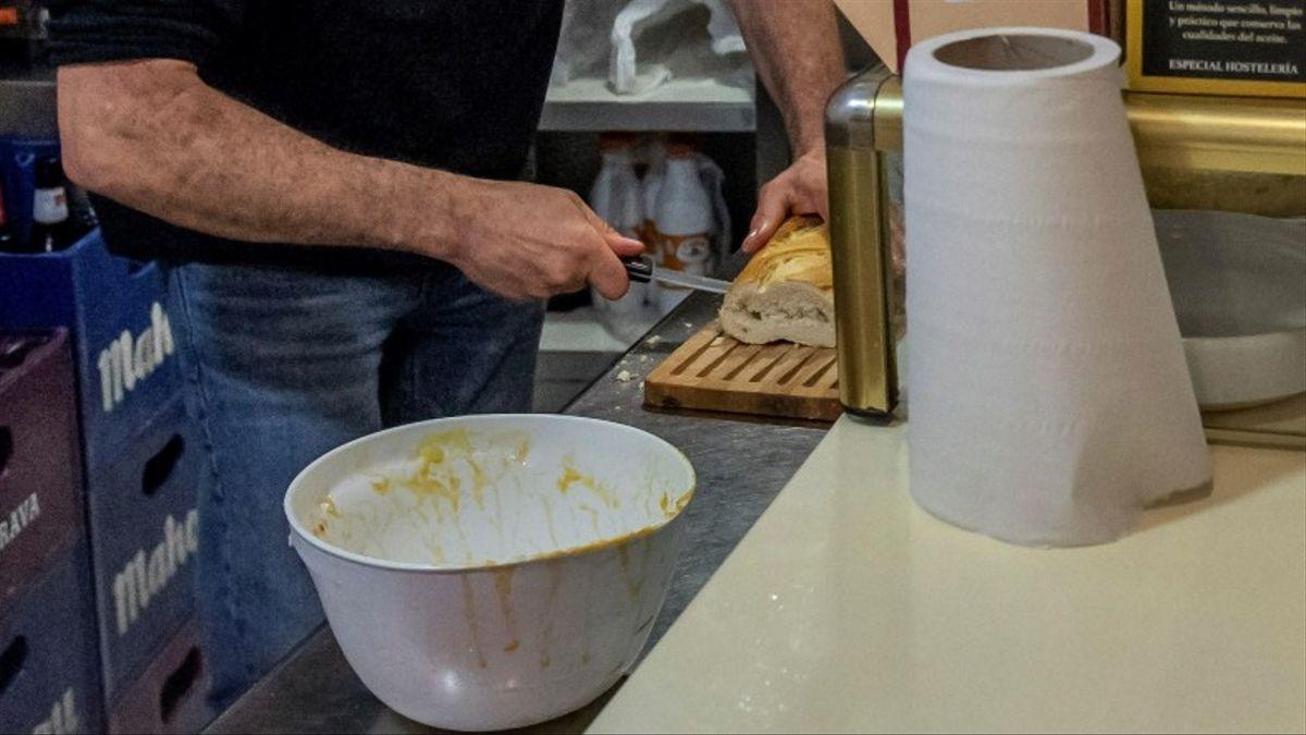 Un hombre corta pan en la cocina de un bar. / Efe / Ismael Herrero