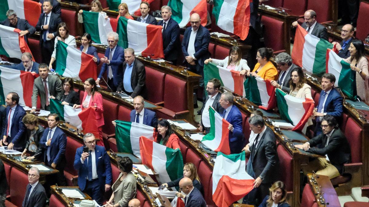 Diputados de la oposición muestran banderas de Italia durante la votación de la ley autonómica, este miércoles en la Cámara baja.