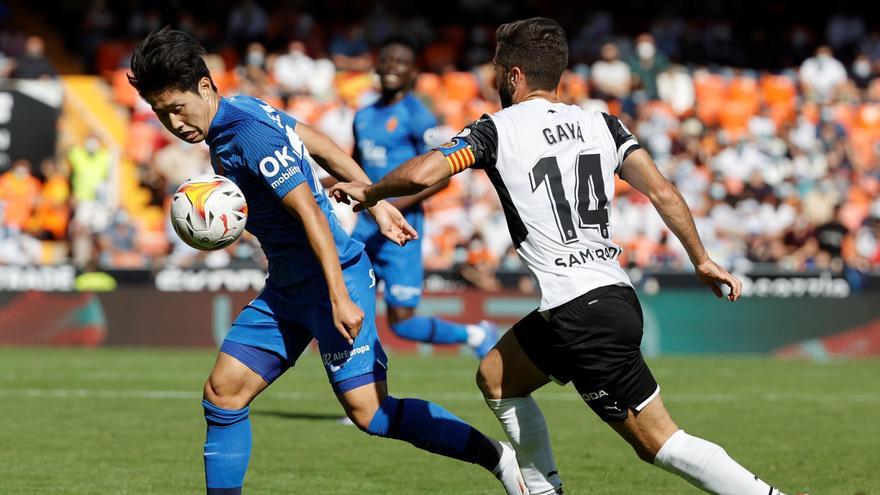 El defensa del Valencia, José Luis Gayá (d) lucha por el balón con el centrocampista surcoreano Lee Kang-In (i) del Mallorca.