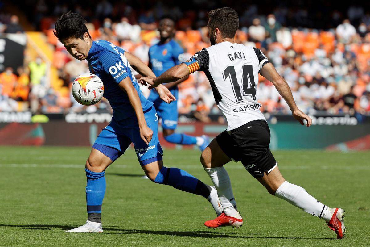 El defensa del Valencia, José Luis Gayá (d) lucha por el balón con el centrocampista surcoreano Lee Kang-In (i) del Mallorca.