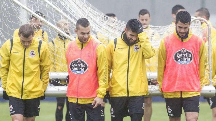 Álex Bergantiños, Fariña, Juanfran e Insua transportan una portería sobre el césped de Abegondo.