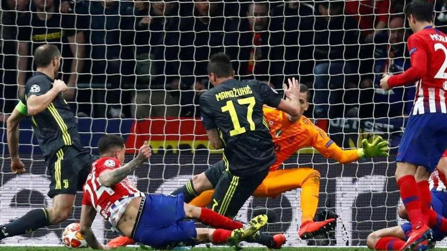 Giménez, desde el suelo, remata en la jugada del primer gol del Atlético.