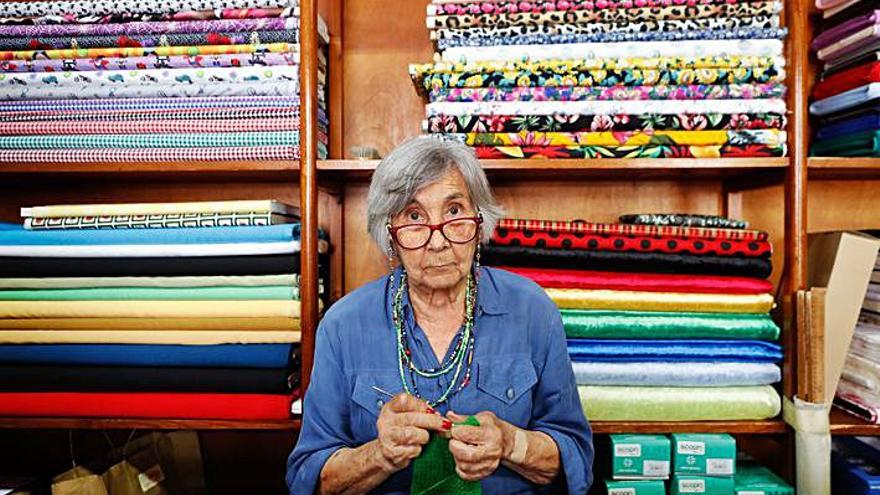 Dorita, que sigue al frente del negocio a sus 83 años, haciendo ganchillo detrás del mostrador. 