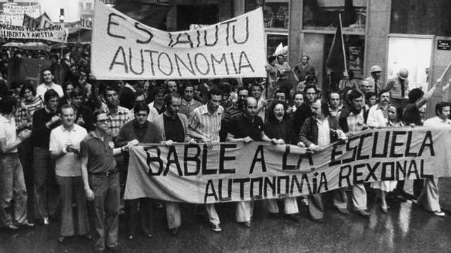 Por la izquierda, con la pancarta, Cheni Uría, José Luis Riopedre (con Areces a su espalda), Ramón Rañada, Jesús Sanjurjo, José Luis Iglesias, Lluis Xabel Álvarez, Pedro de Silva (en segunda fila), Avelino López, José Bolado (en segunda fila), Miguel Ramos Corrada, Amelia Valcárcel y el sindicalista «El Roxu». | Conceyu Bable