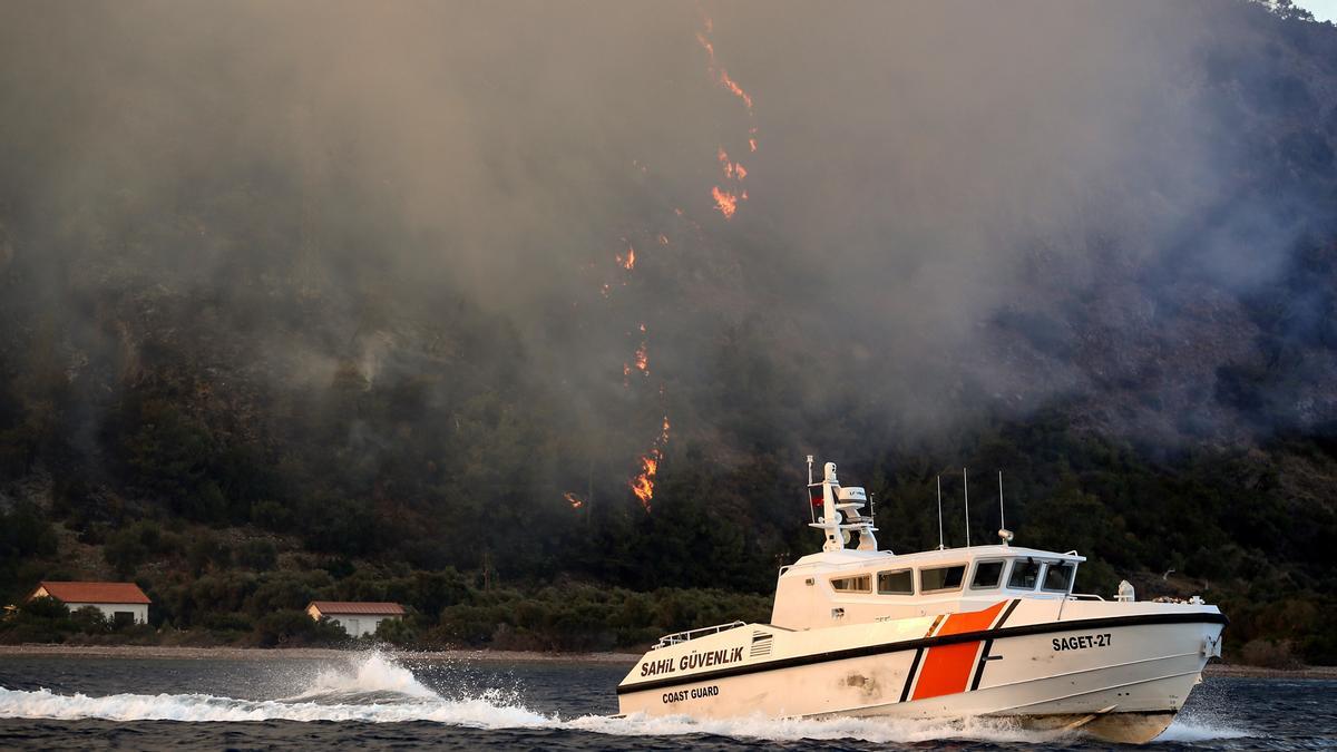 Un barco de la Guardia Costera huye de las llamas en Turquía.