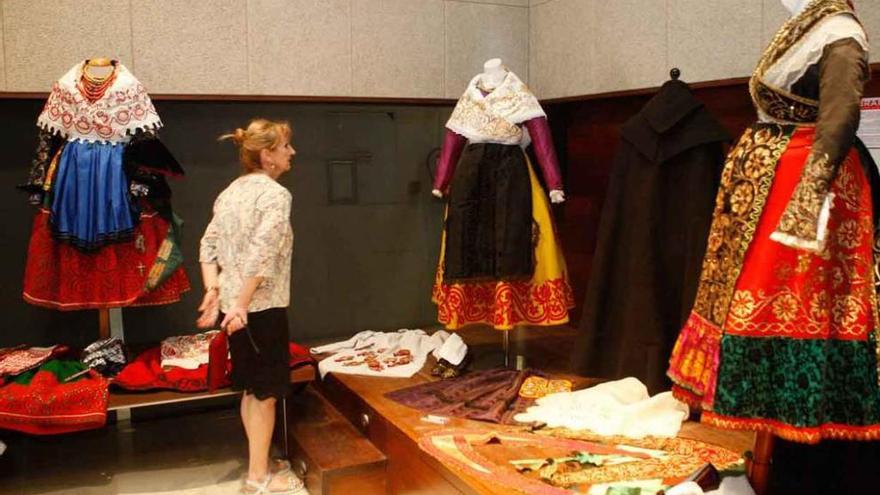 Una visitante observa los trajes elaborados por los socios de La Morana en el Etnográfico.