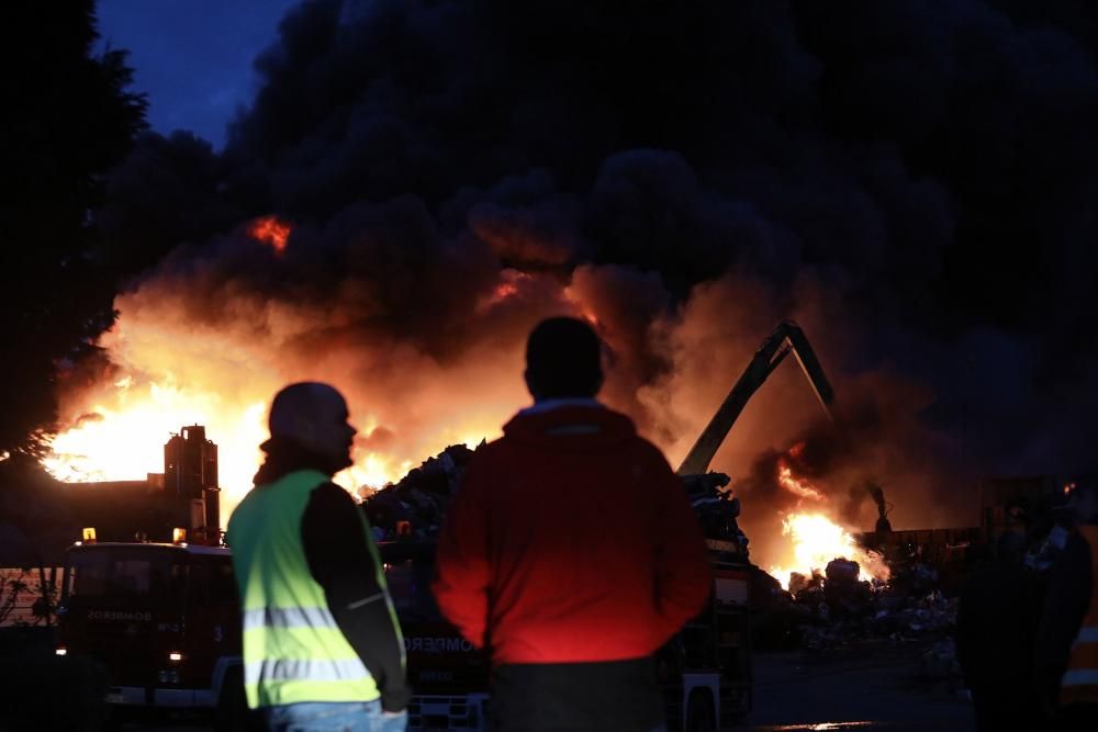 Labores de extinción del incendio de un desguace en Gijón