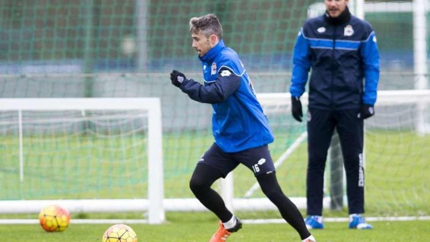 Luisinho conduce el balón sobre el césped de Abegondo en presencia de Víctor Sánchez.