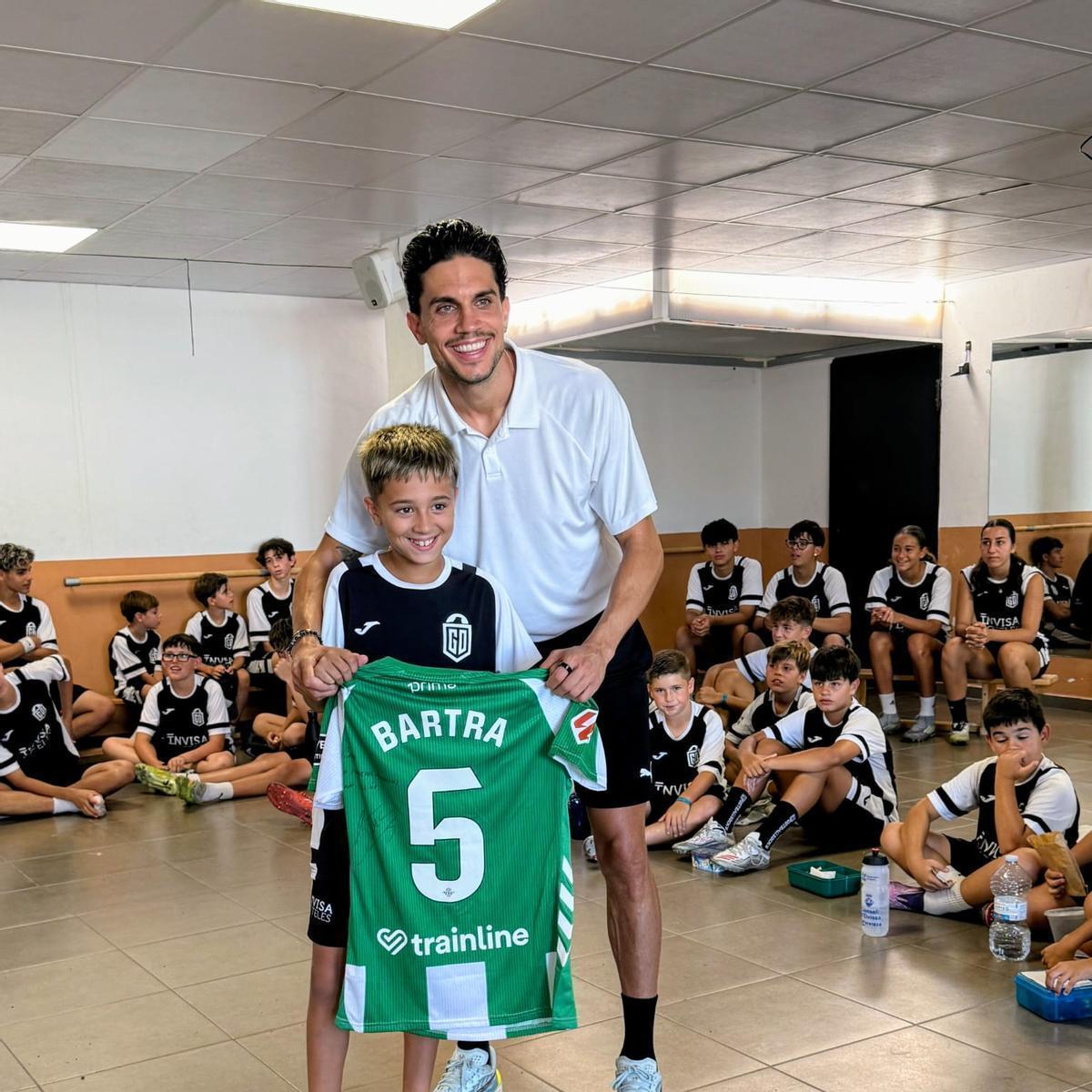 Marc Bartra posa con un niño con la camiseta que porta en el Real Betis.