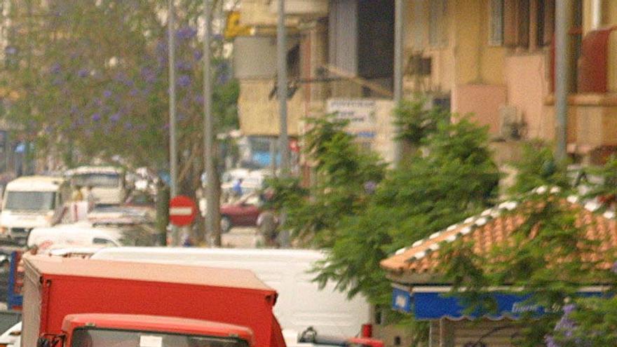 Varios coches en doble fila en una calle de Málaga.