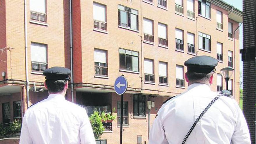 Los agentes de la Policía Nacional miran el edificio de Lugones en el que rescataron a la mujer.