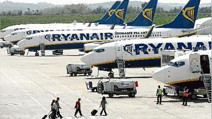 Passatgers dirigint-se als avions de Ryanair aparcats a l&#039;aeroport de Girona-Costa Brava.