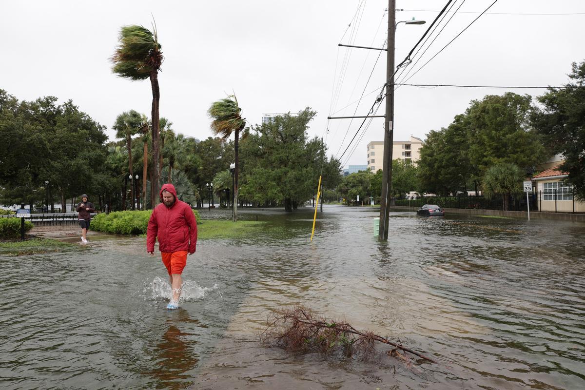 Orlando (United States), 29/09/2022.- People walk in flood waters in the wake of Hurricane Ian in Orlando, Florida, USA, 29 September 2022. Hurricane Ian came ashore as a Category 4 hurricane according to the National Hurricane Center and is nearing an exit into the Atlantic Ocean on the East Coast of Florida. (Estados Unidos) EFE/EPA/GARY BOGDON