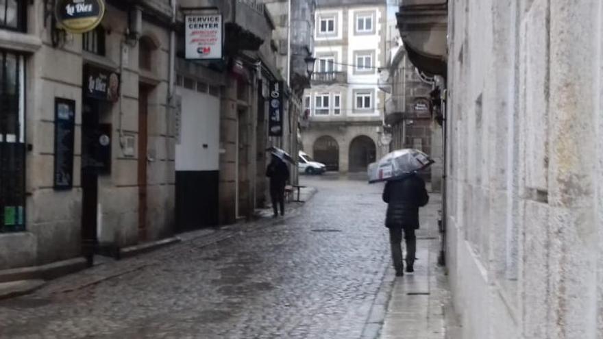 Viandantes tratan de protegerse de la lluvia en Vigo // Alba Villar