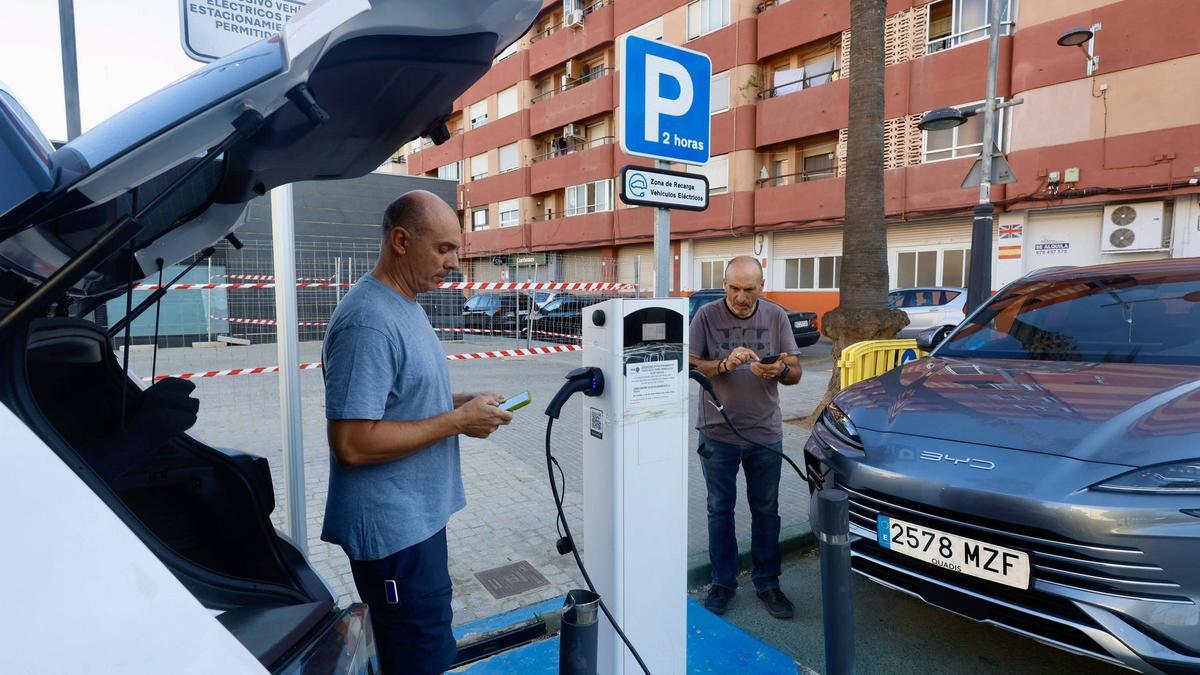 Dos conductores activan la carga desde su móvil en un cargador público en Sedaví.