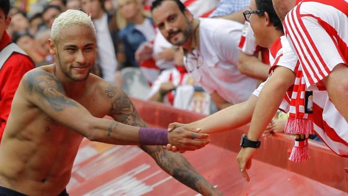 Neymar entrega su camiseta a una persona con minusvalía en El Molinón.