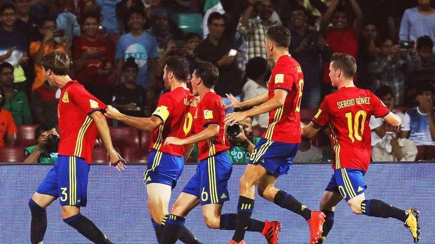 Abel Ruiz (izqda.) es felicitado por sus compañeros tras marcar, de penalti, el primer gol español. // Efe