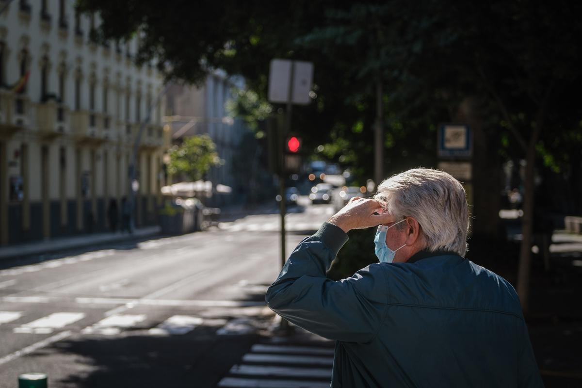 Un hombre otea el horizonte antes de cruzar la calle en Santa Cruz de Tenerife.