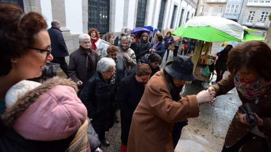 Arriba y a la izquierda, dos imágenes de los fieles que acudieron, ayer, para renovar la tradición de las Tres Gracias. // GS