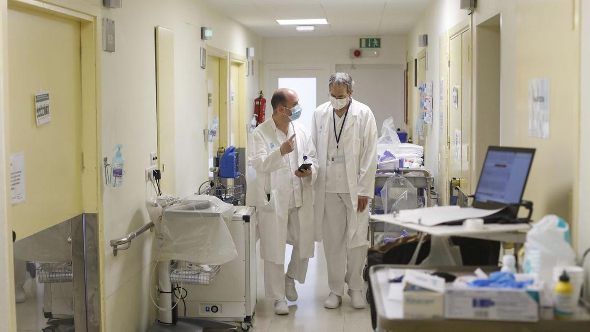 Dos treballadors de l’Hospital Josep Trueta de Girona en un passadís. | ANIOL RESCLOSA