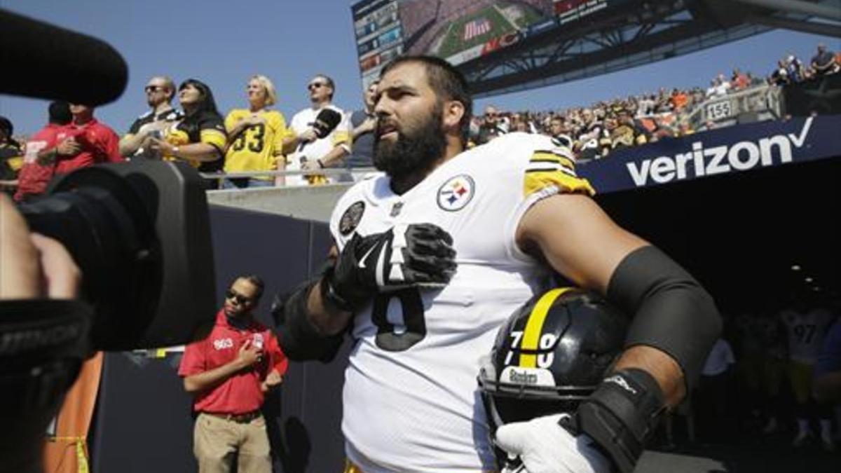 El jugador de los Steelers Alejandro Villanueva escucha solo el himno estadounidense antes de un partido.