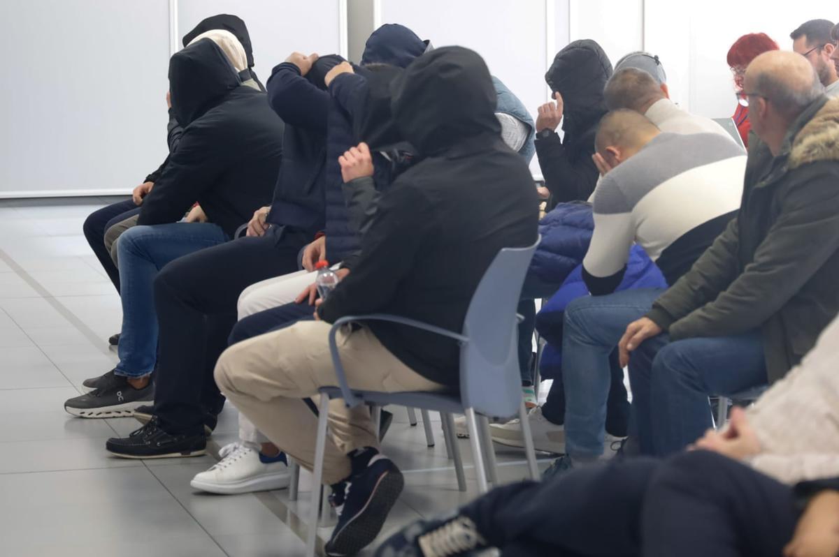 Los 14 acusados, en el banquillo, ocultan sus rostros durante la última sesión del juicio por la trama de Sky.