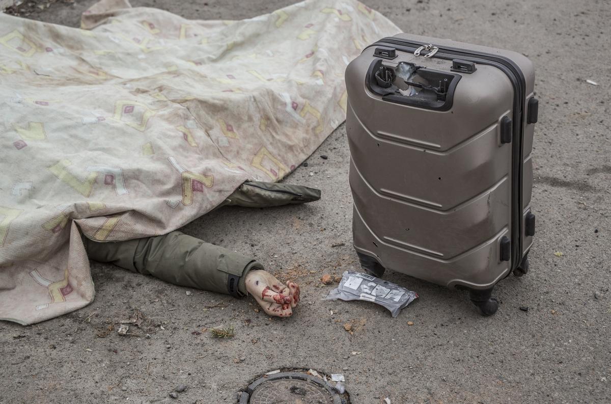 El cadáver de una civil yace en la calle junto a una maleta, después de no poder huir del fuego enemigo en su intento de escapar del combate en la ciudad de Irpin , el 6 de marzo de 2022.