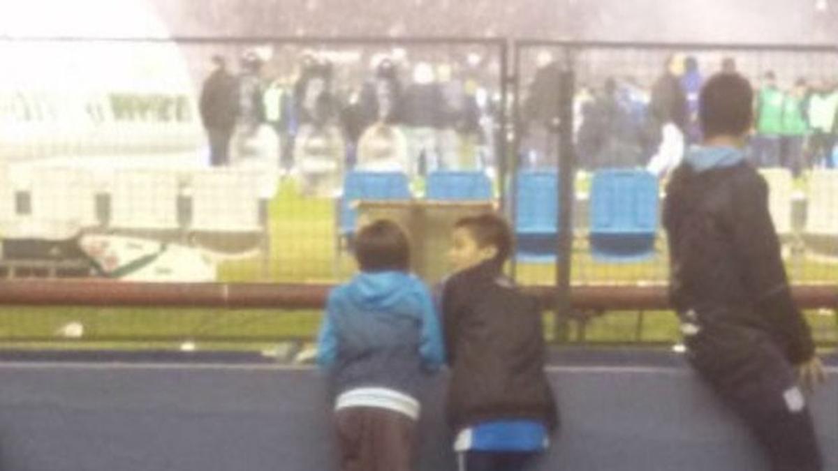 Santy y su amigo, encaramados en las muletas del primero para ver el partido del Racing Club Avellaneda, en Argentina.