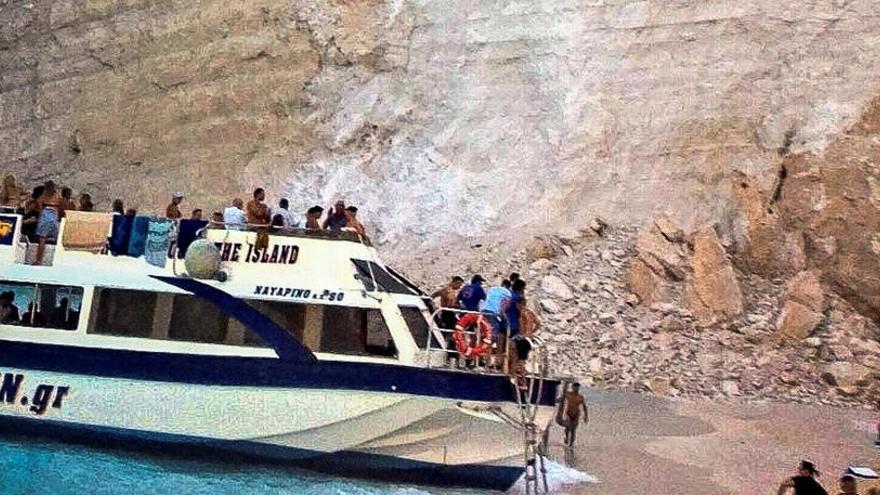 Una embarcación junto a la pared de rocas desprendidas